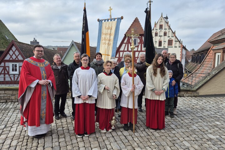 Pfarrer Nicolas Kehl mit den Fahnenabordnungen und dem liturgischen Dienst